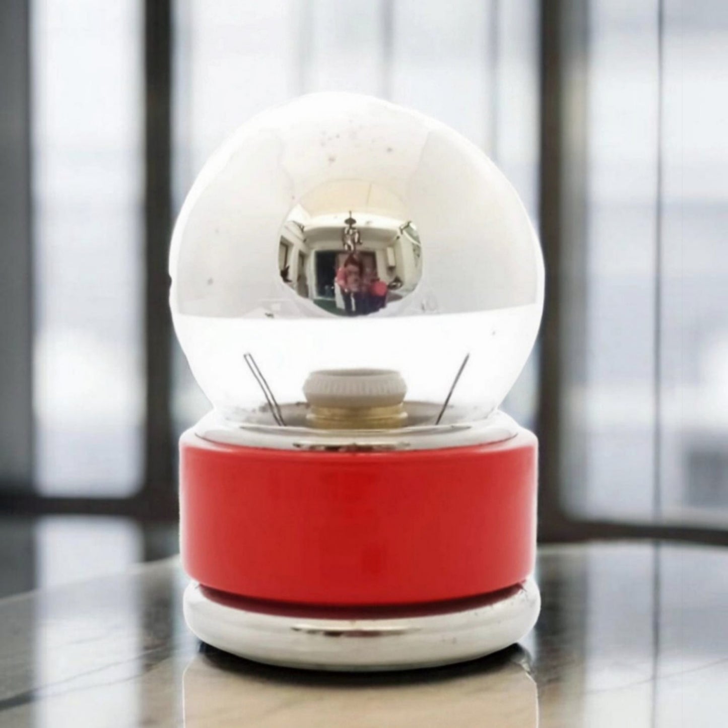Vintage red globe table lamp displayed beside a window