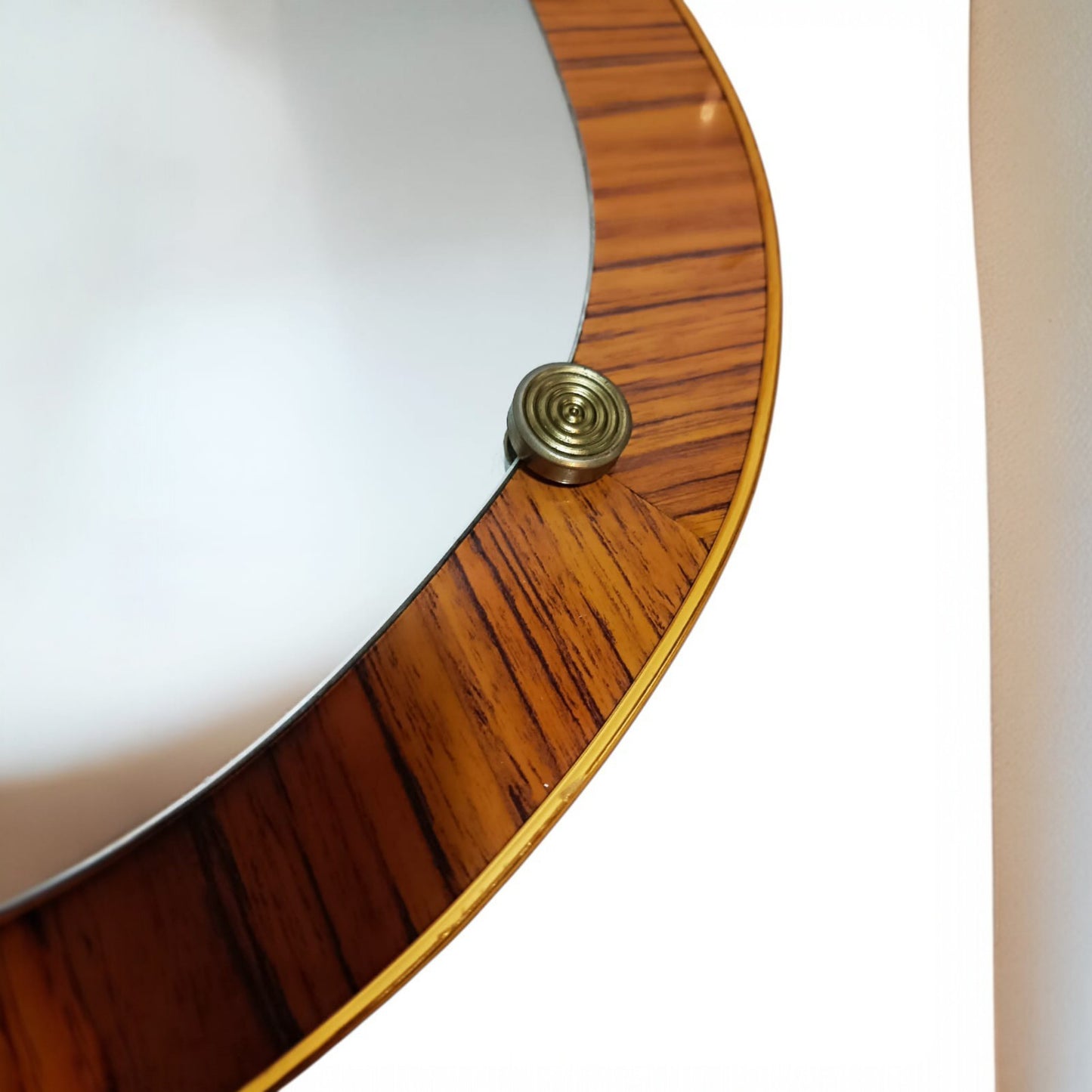 Close view of the brass-toned fixing detail and wood veneer