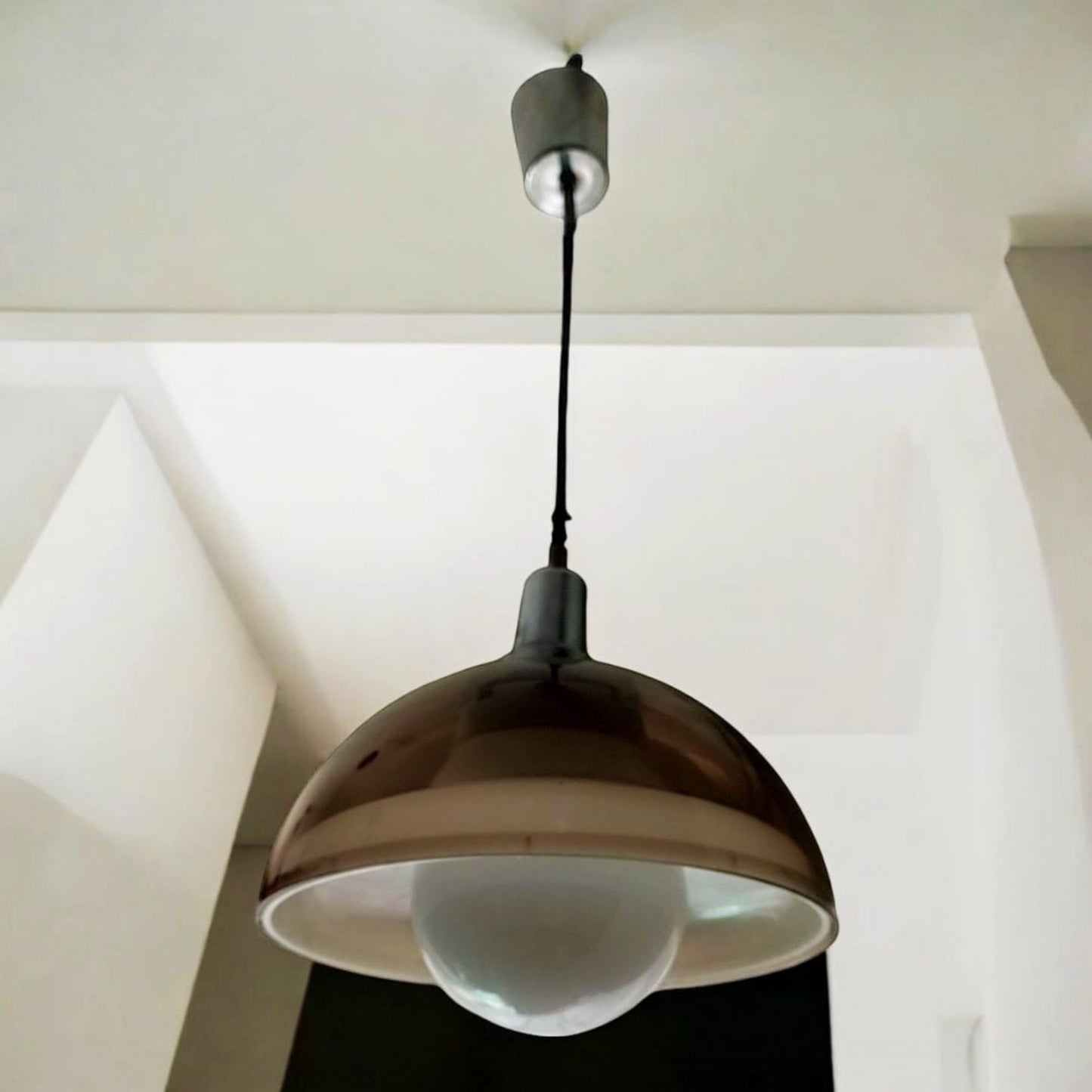 Vintage smoked pendant light suspended against a white interior