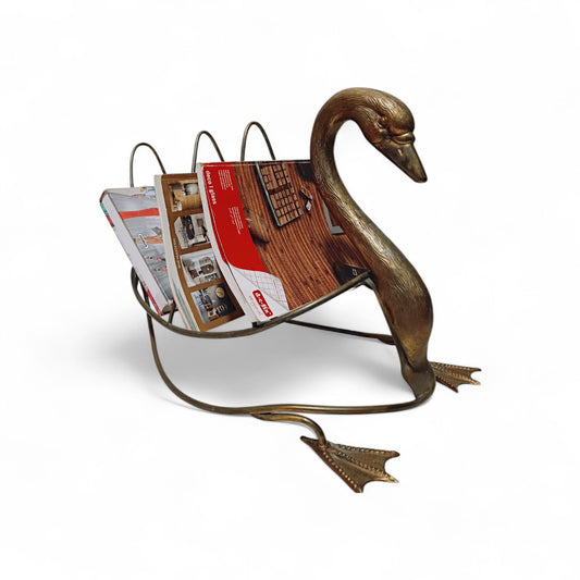 Vintage swan-shaped magazine rack in brass-toned metal displayed with magazines