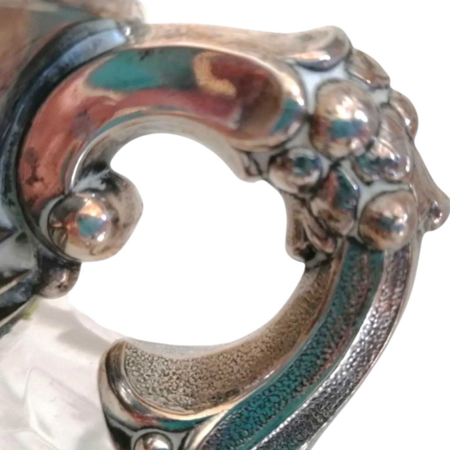 Close-up of the ornate metal handle on the vintage vase.