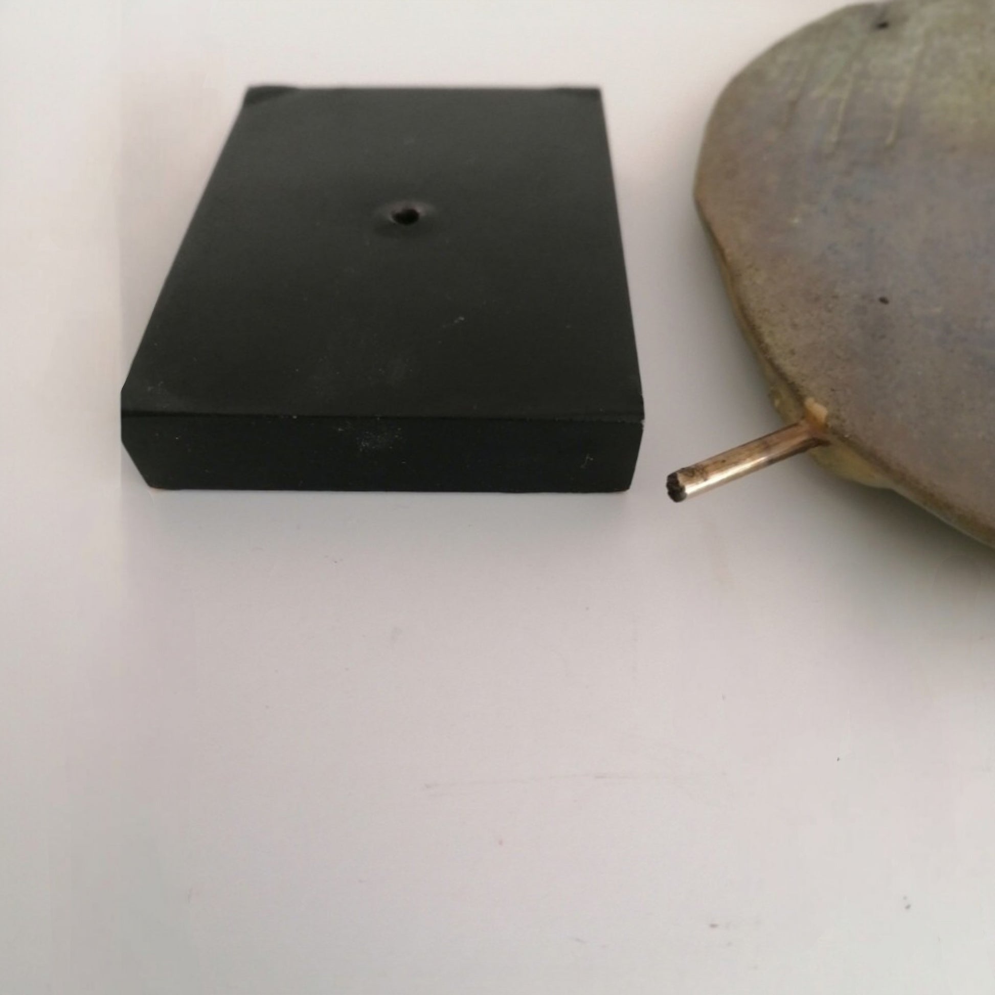 Black wooden base and metal support of the ceramic dove sculpture 