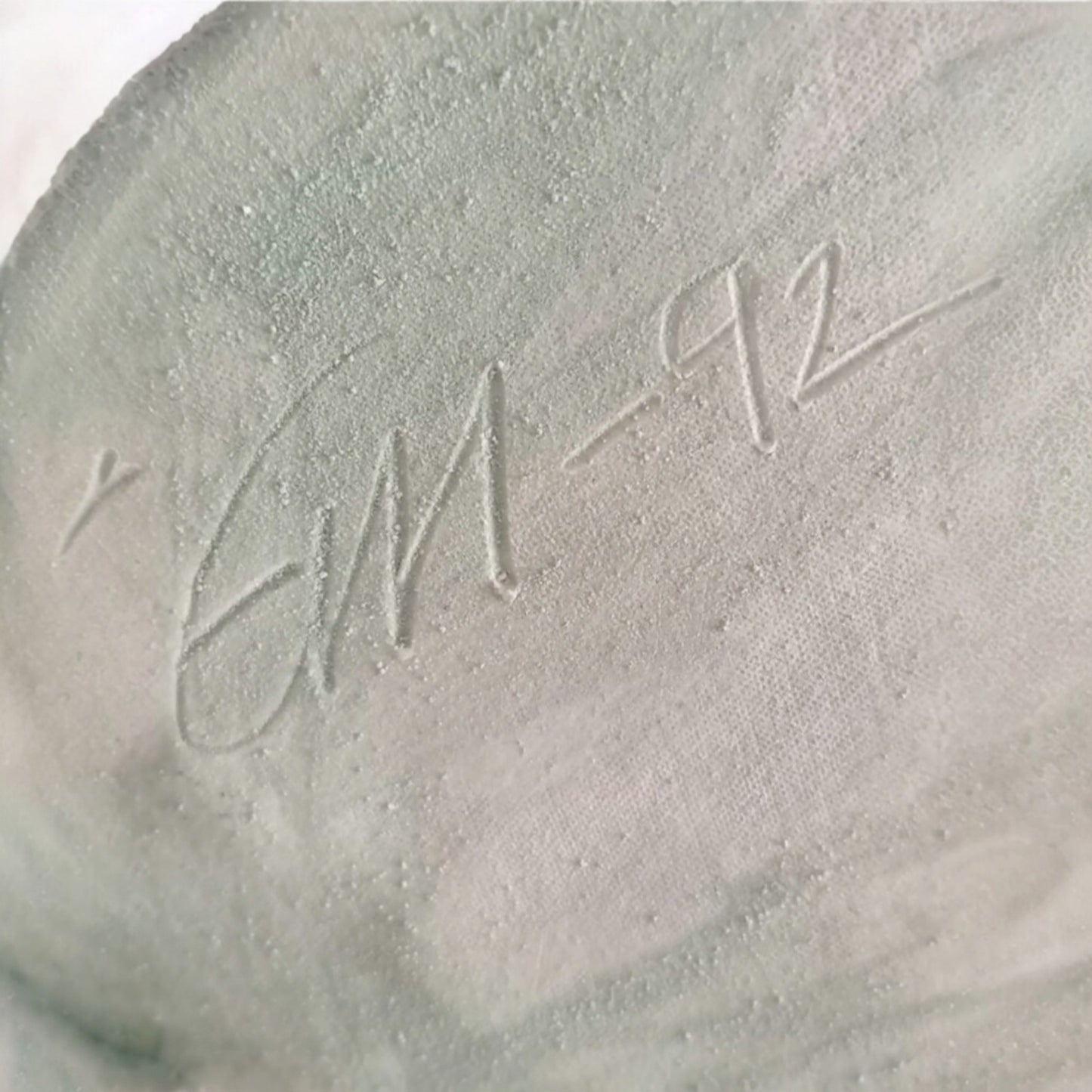 Artist’s engraved signature and date on the ceramic sculpture 