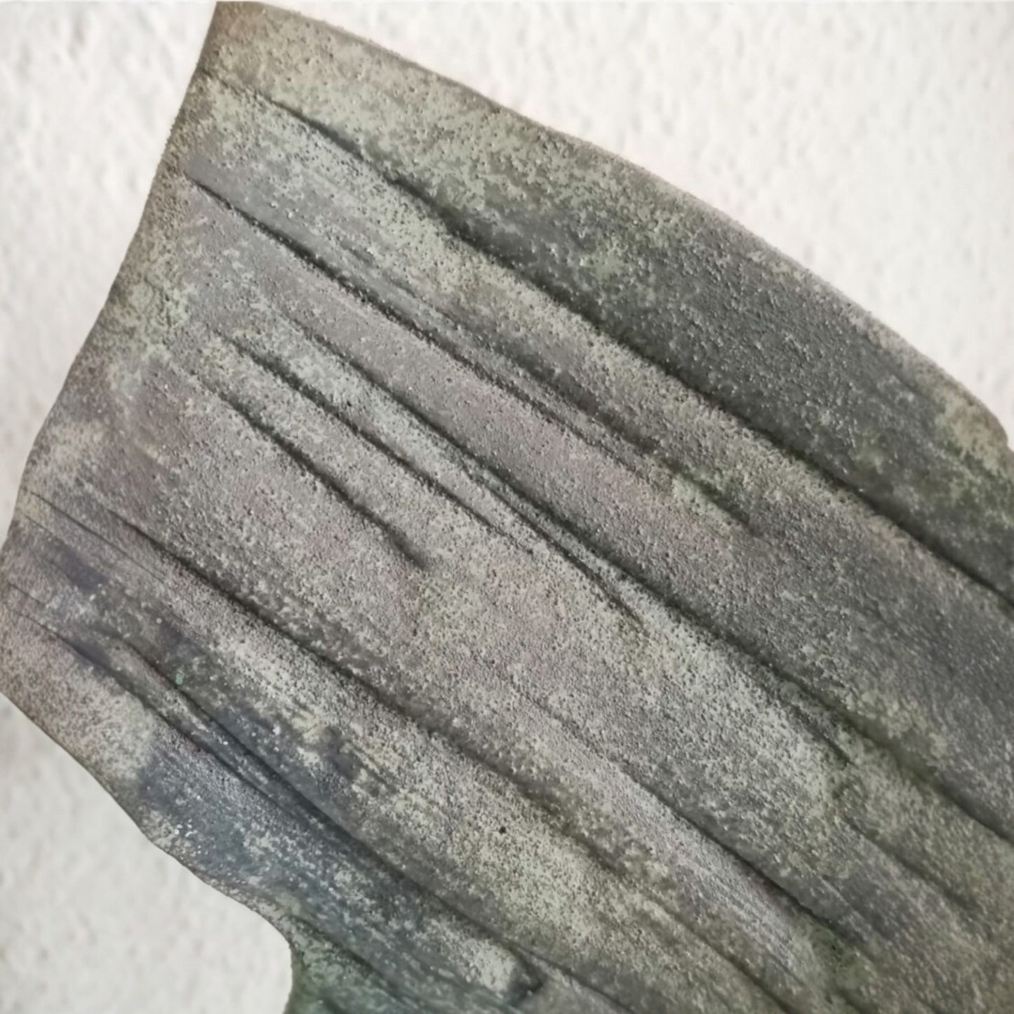 Close view of the incised feather detail on the ceramic dove sculpture 