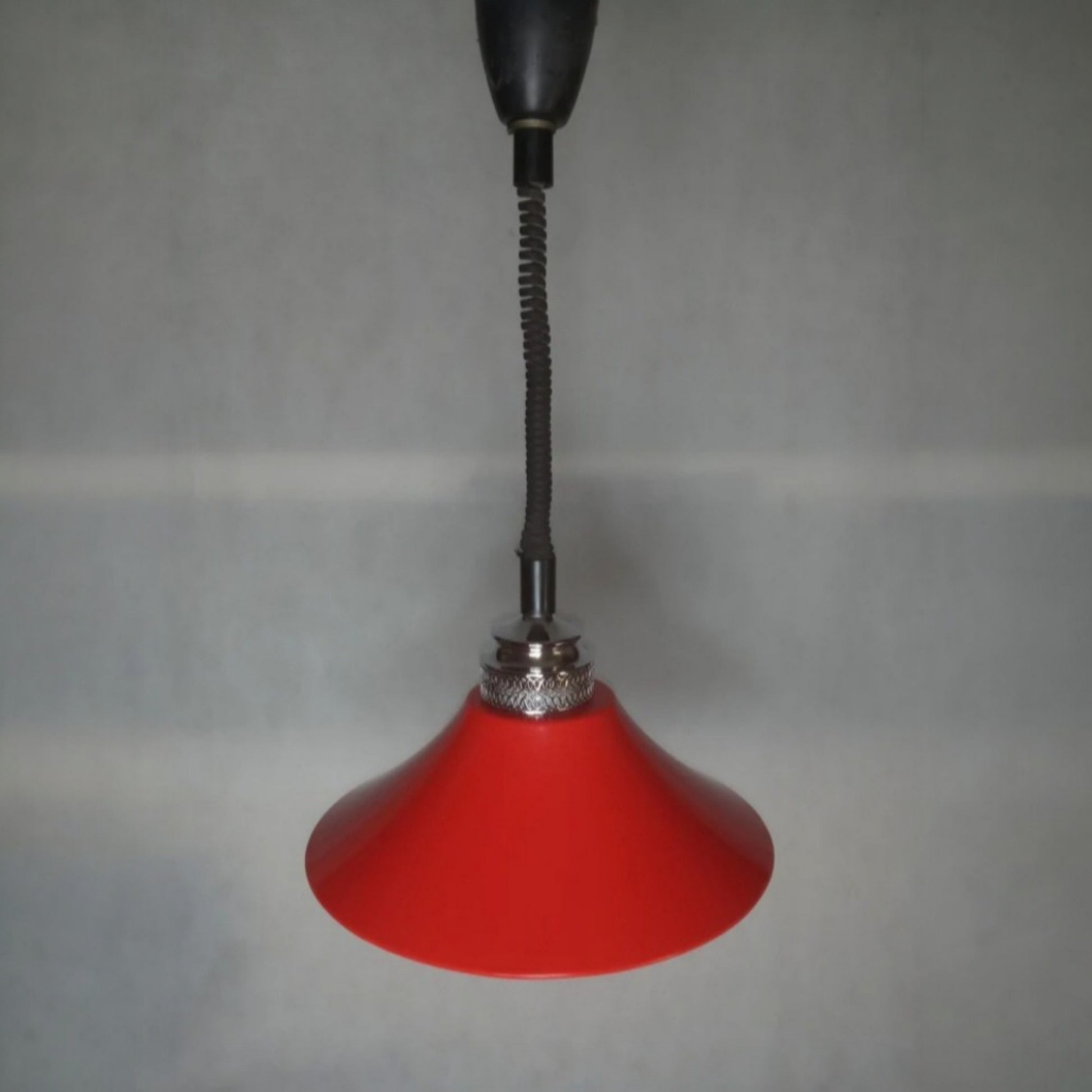 Vintage red pendant lamp suspended against a neutral wall