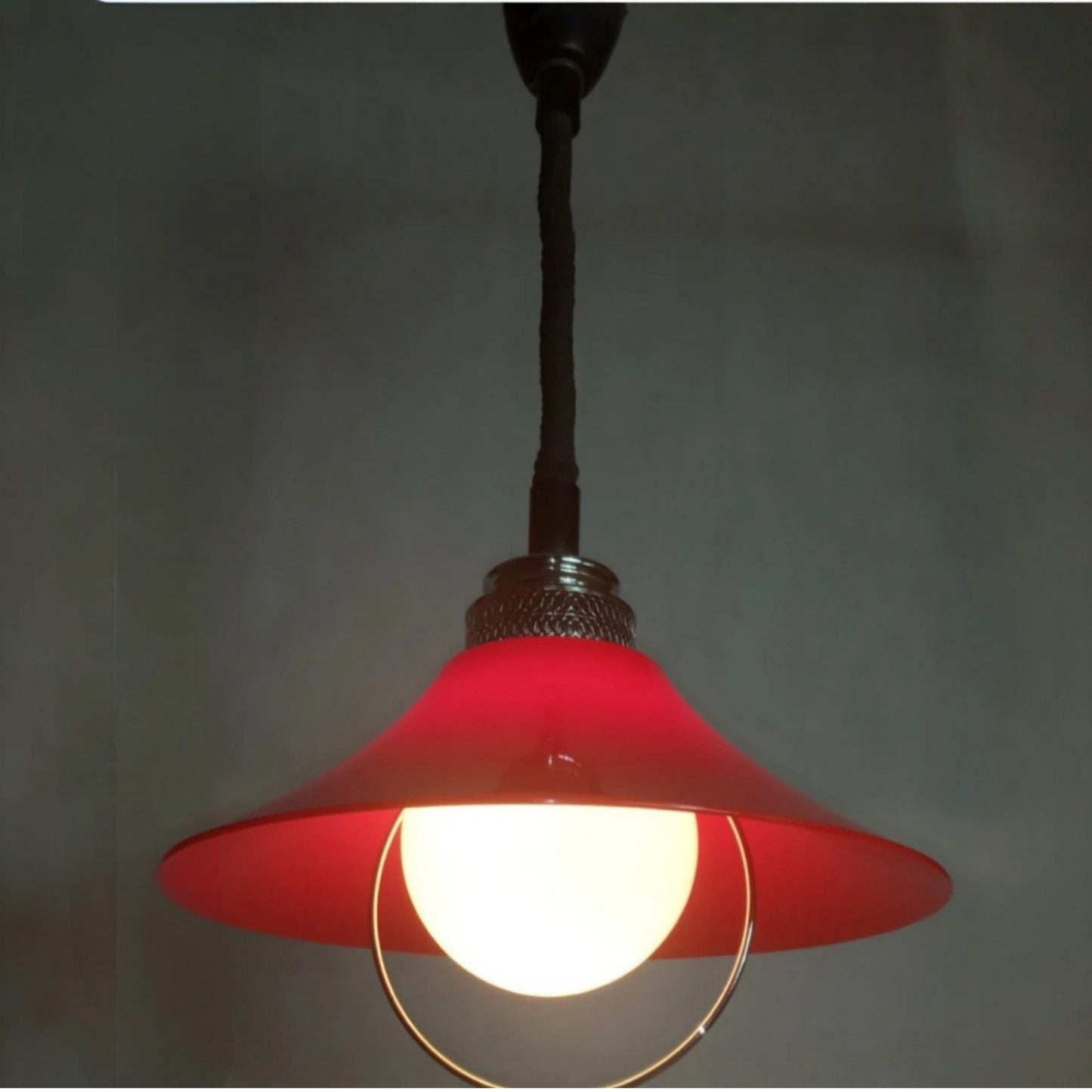 Illuminated pendant lamp showing the softly glowing opaline glass diffuser