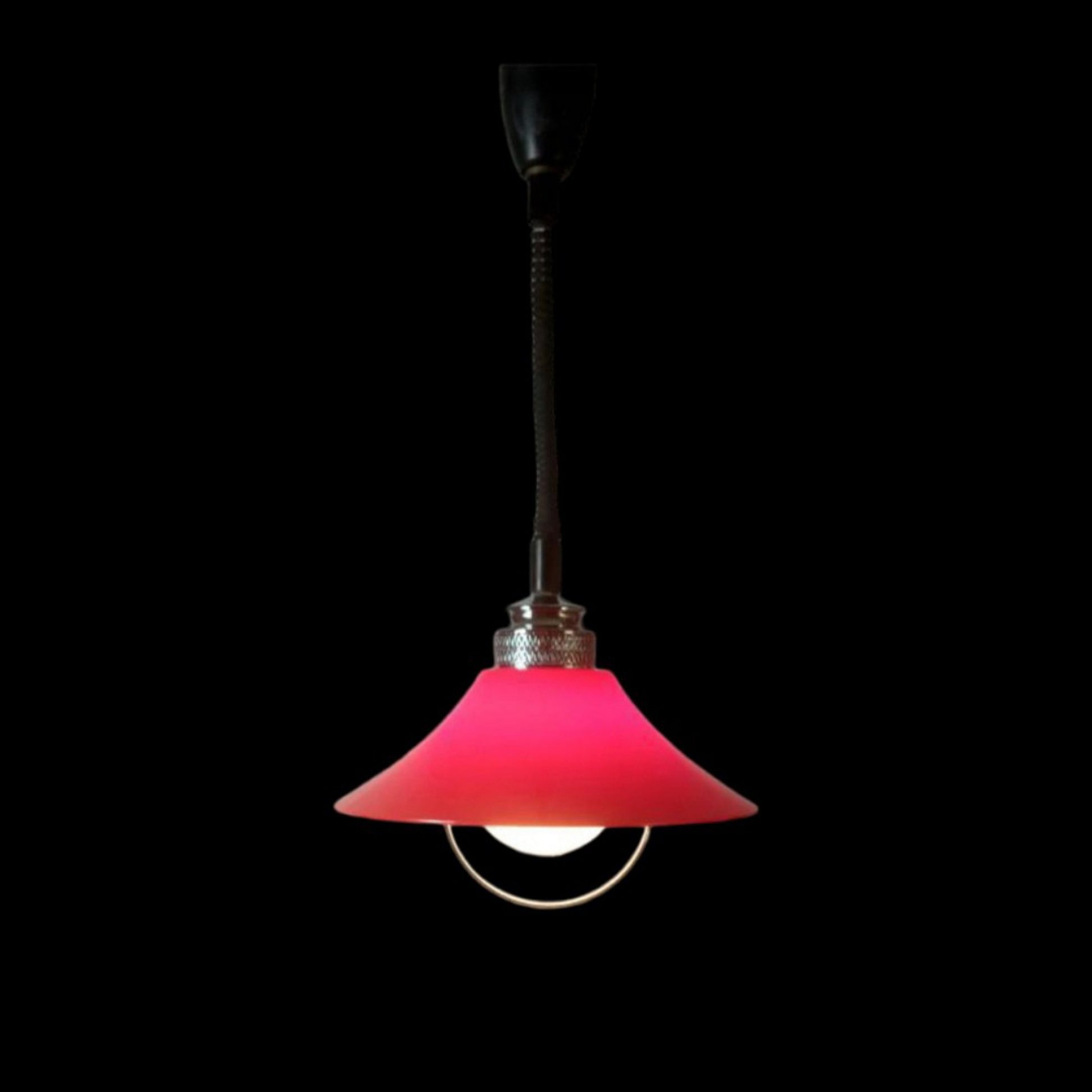Red Space Age pendant lamp illuminated against a dark background