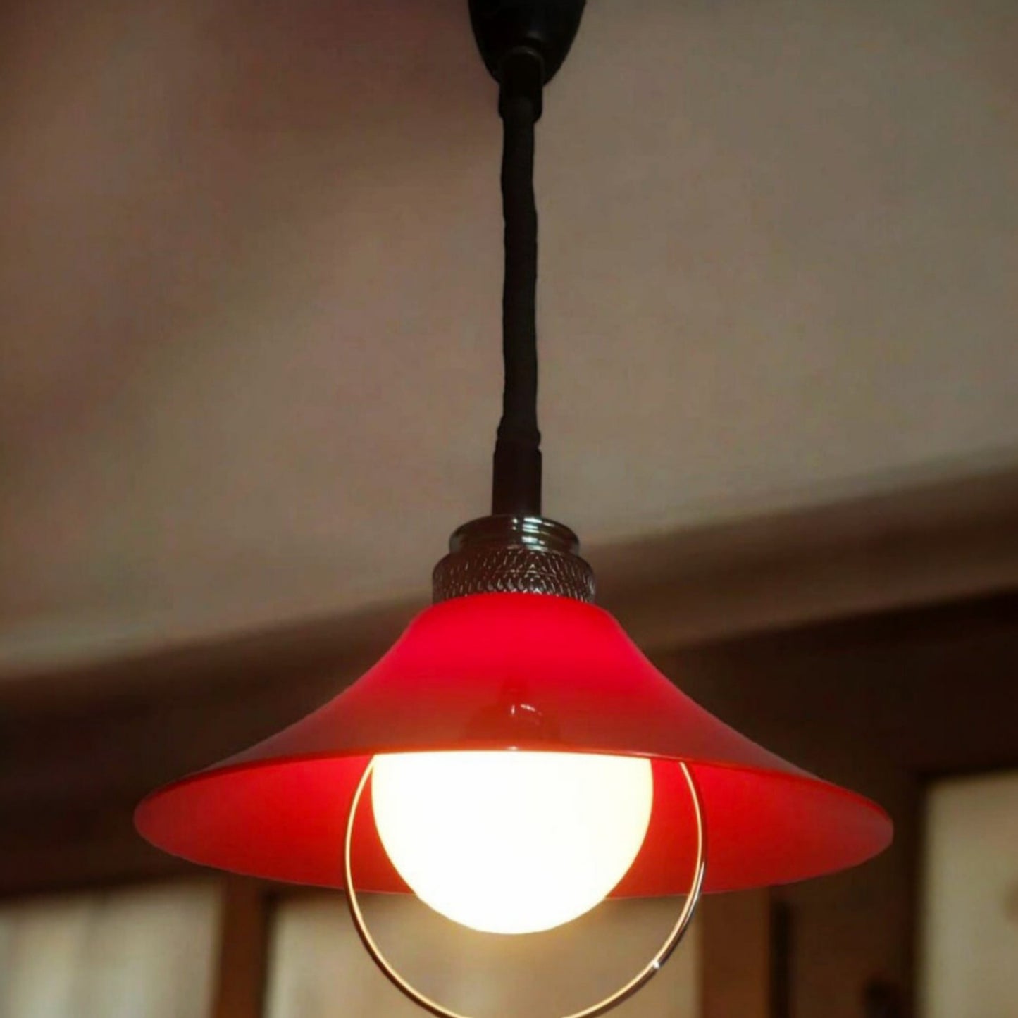 Illuminated pendant lamp showing the softly glowing opaline glass diffuser