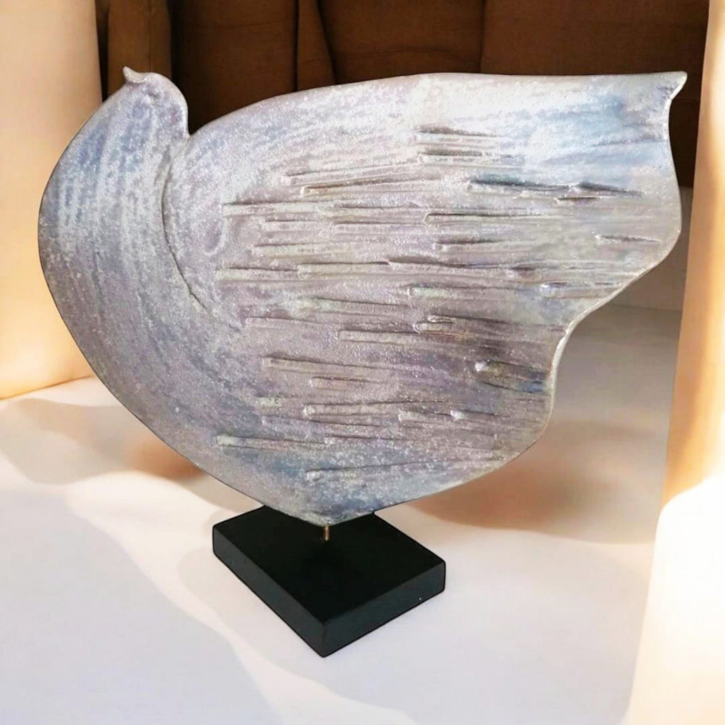 Front view of the ceramic dove sculpture showing rounded wing and textured surface