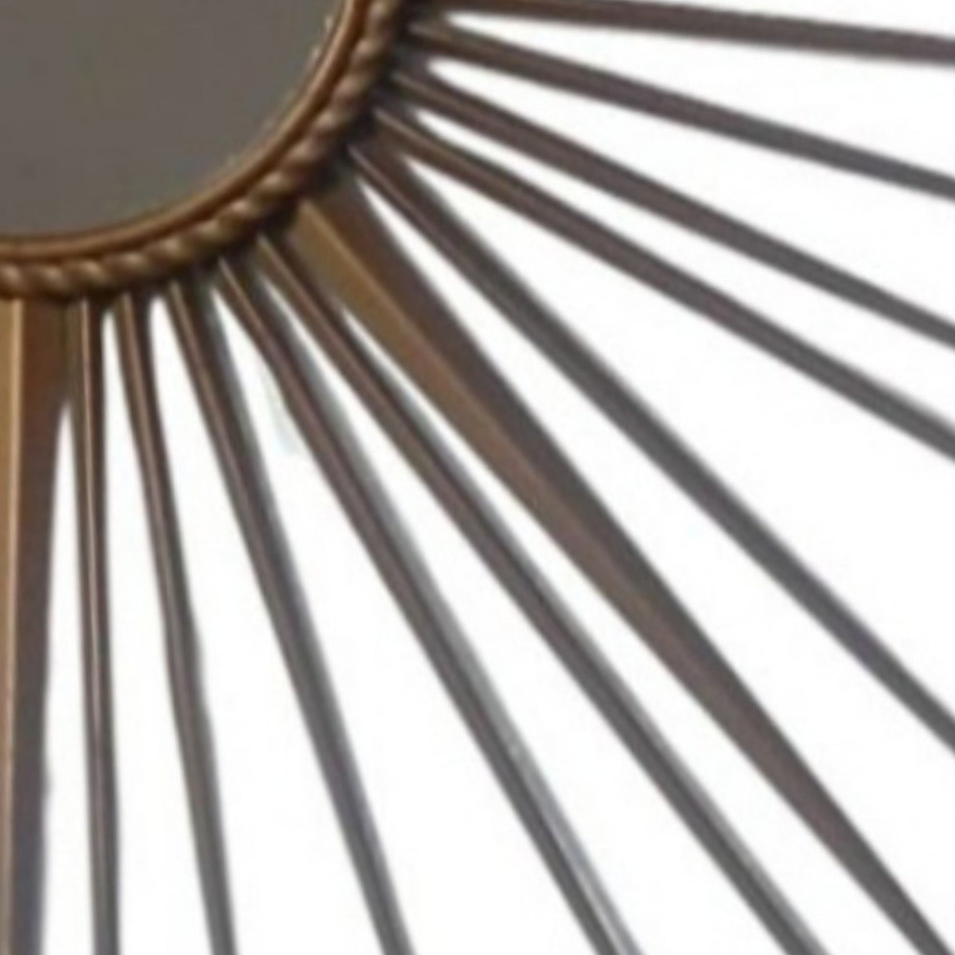 Close-up of the slender metal rays surrounding the circular mirror.