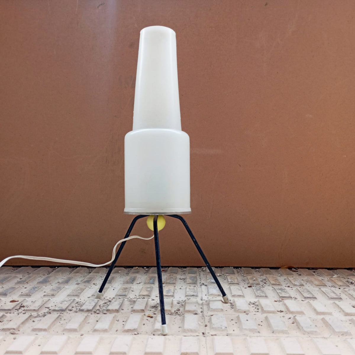 Opal plastic table lamp against a warm-toned wall