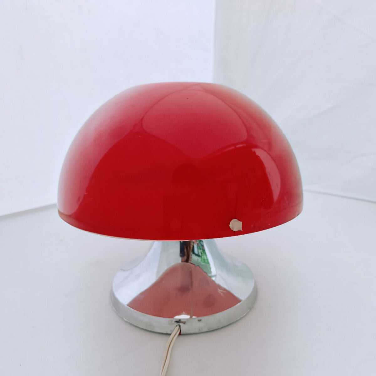 Red IXO table lamp with domed shade and chrome-effect flared base, showing a small crack to the lower edge of the shade