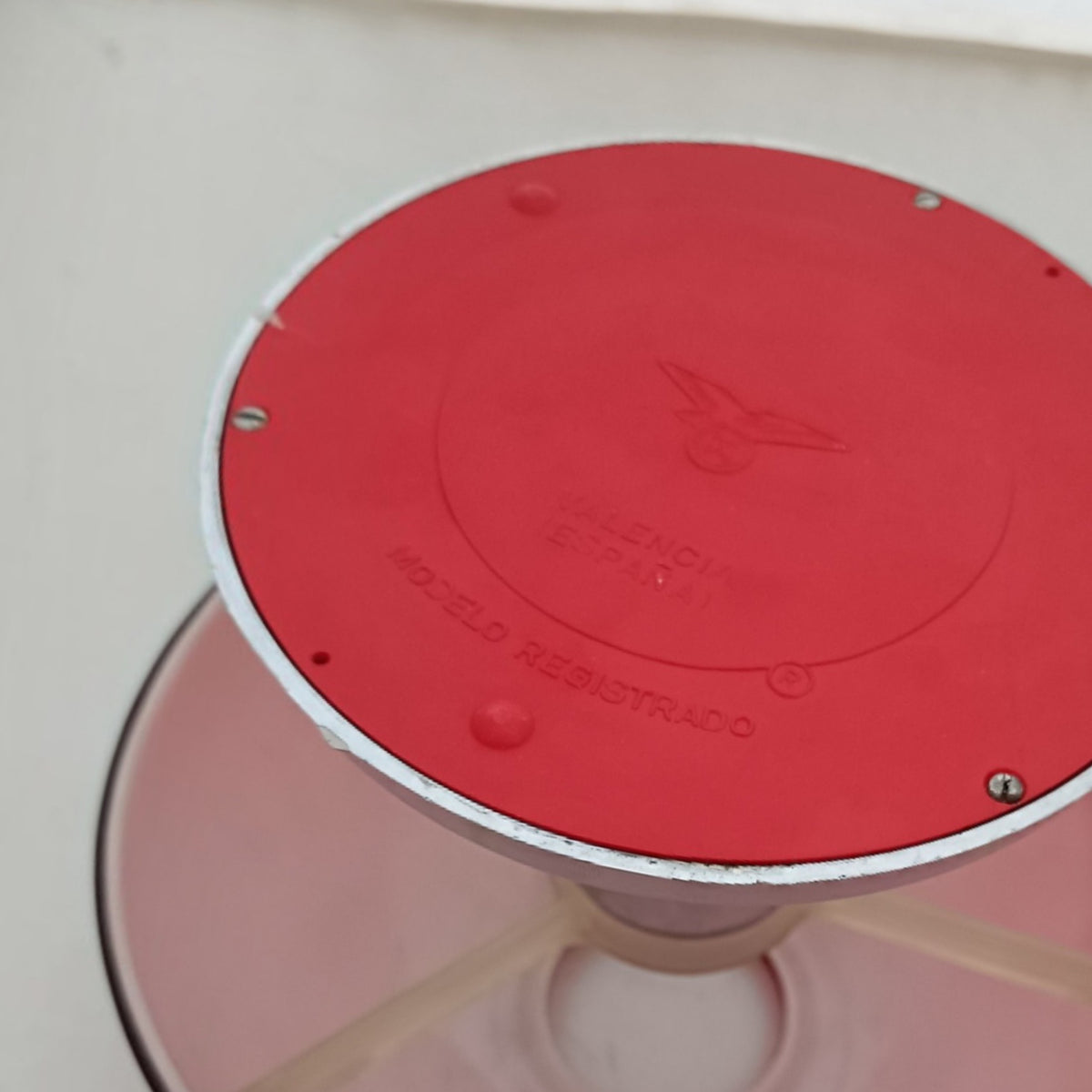 Underside of red IXO table lamp showing the moulded Valencia, Spain and registered model markings