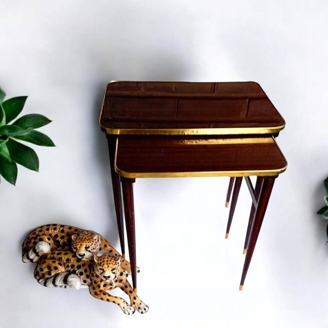 Pair of vintage nesting tables beside decorative objects