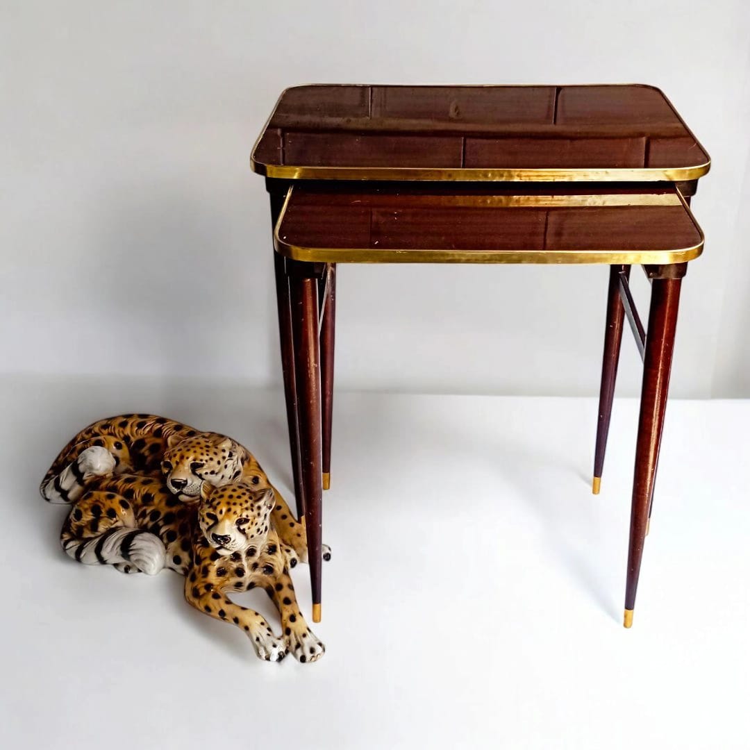 Pair of vintage nesting tables beside decorative objects