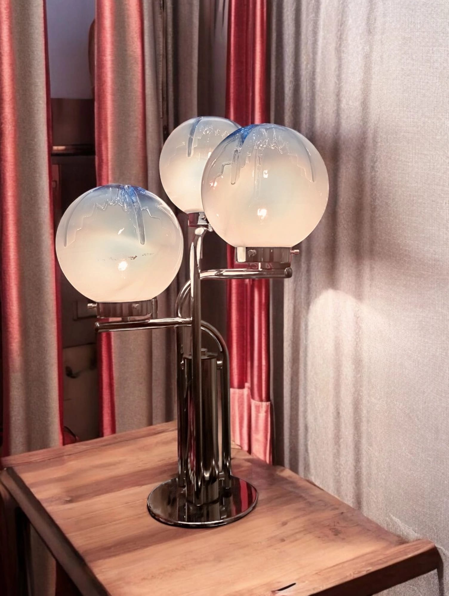 Italian table lamp switched on, chromed metal and glowing glass globes