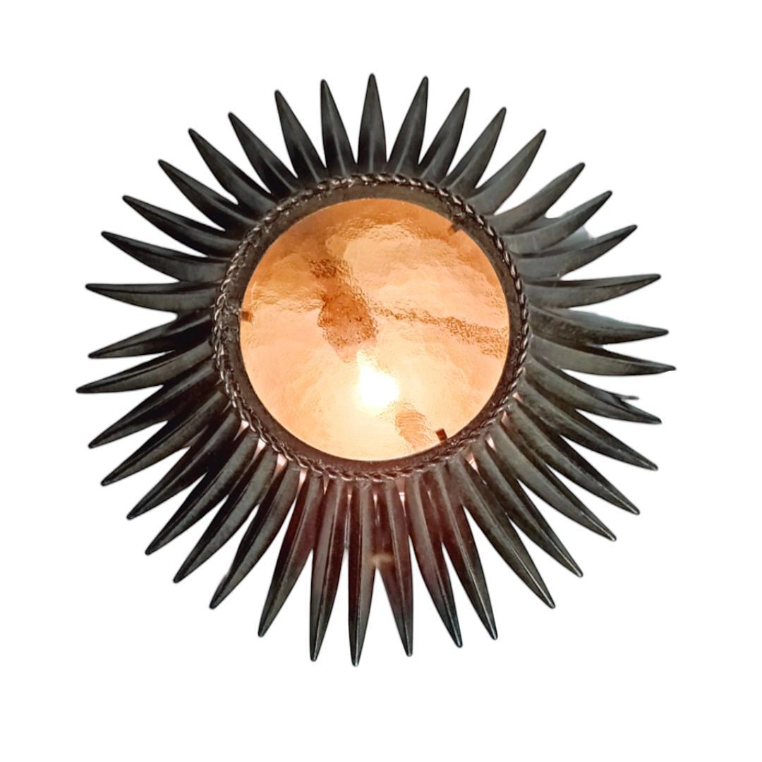 Vintage Sunburst lamp illuminated, showing warm golden glow through the central glass