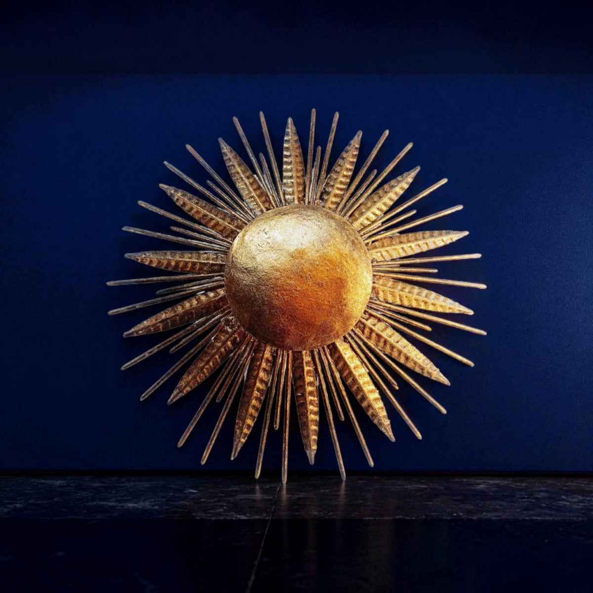 Illuminated sunburst wall light displayed against a dark blue background